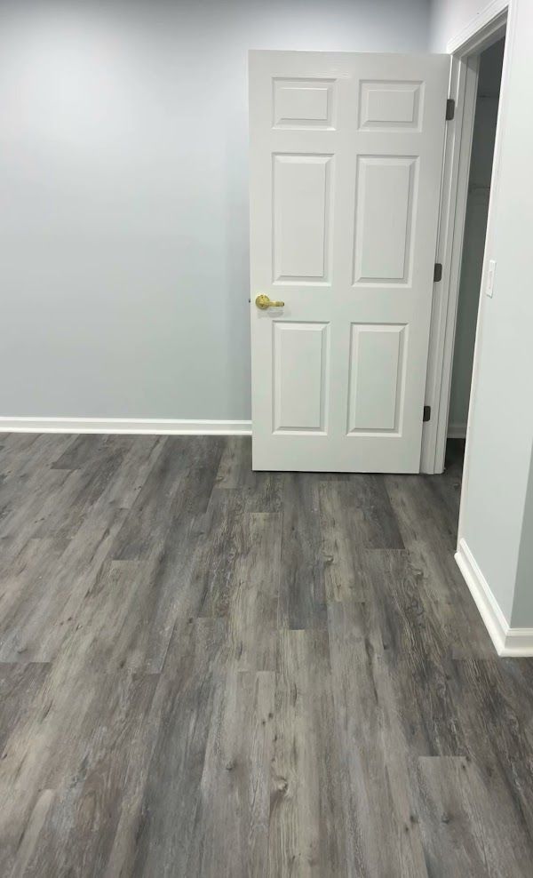 A room with a wooden floor and a white door