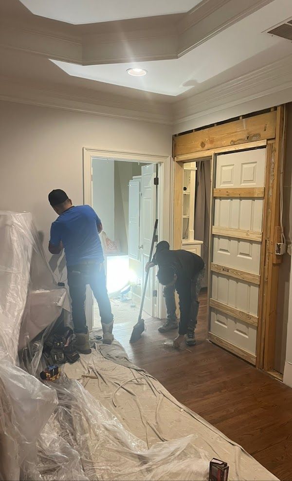 Two men are working on a door in a room