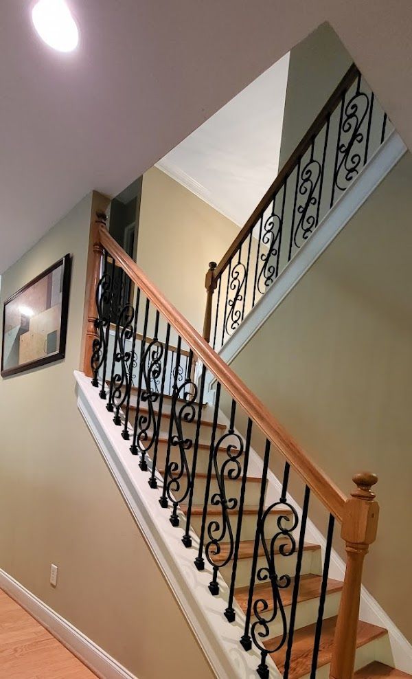 A wooden staircase with a wrought iron railing in a house