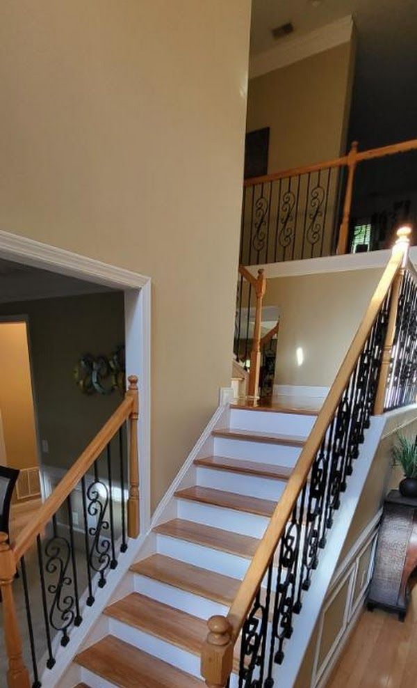 A staircase with wooden steps and a wrought iron railing in a house