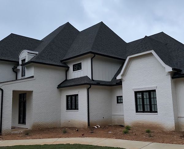 A large white house with a black roof and black windows