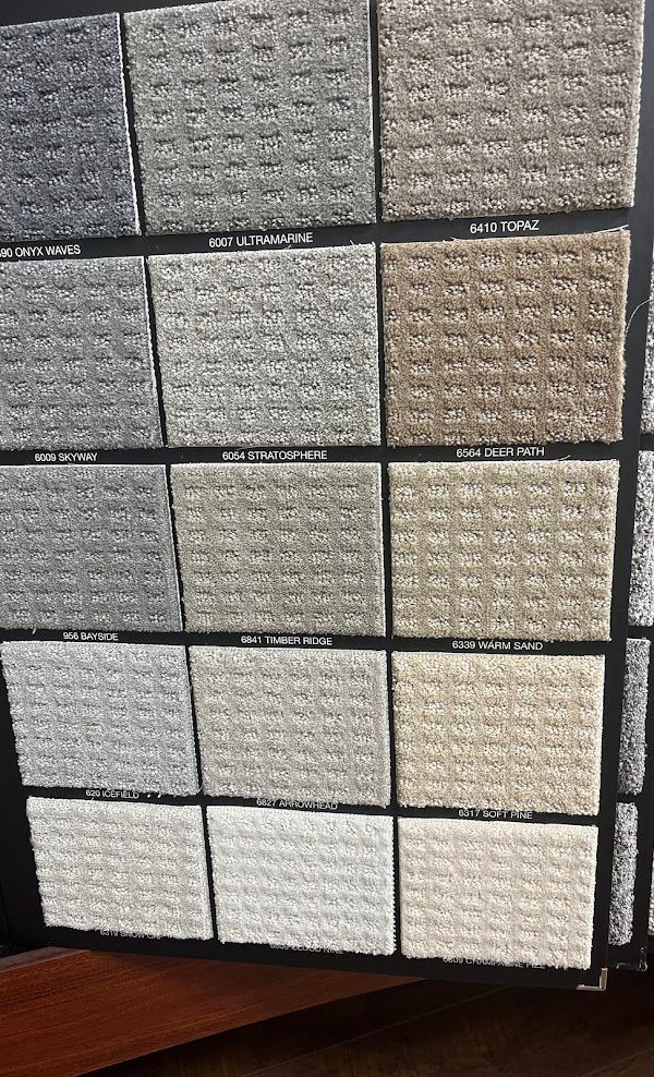 A variety of carpet samples are displayed on a table
