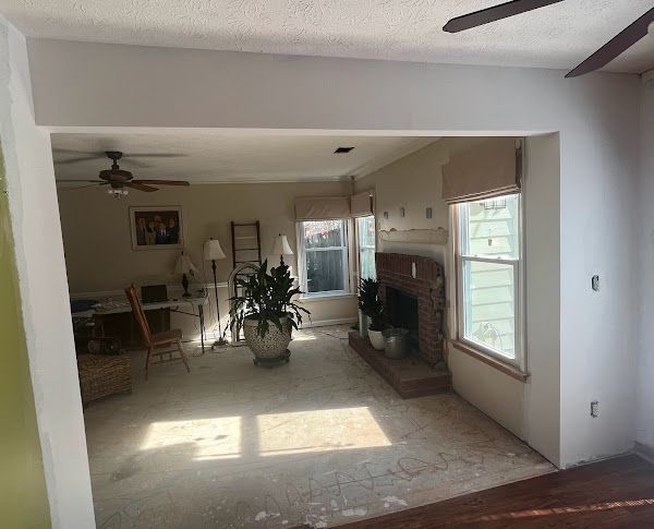 A living room with a fireplace and a ceiling fan