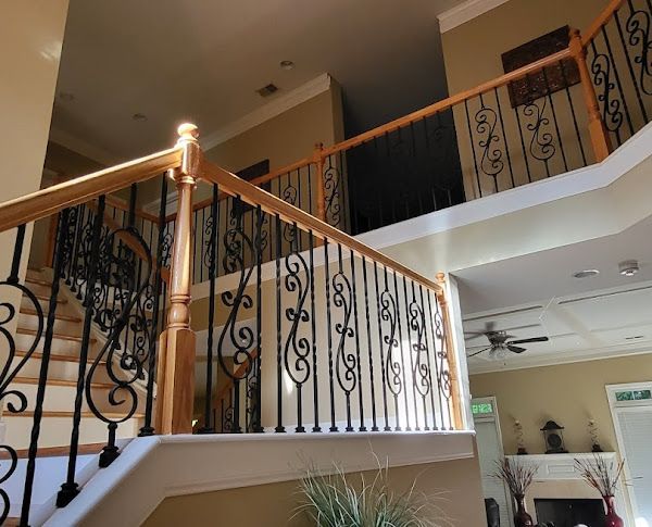 A wooden staircase with a wrought iron railing in a house