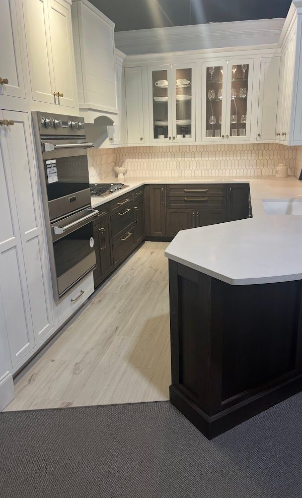 A kitchen with white cabinets and black cabinets and a large island.