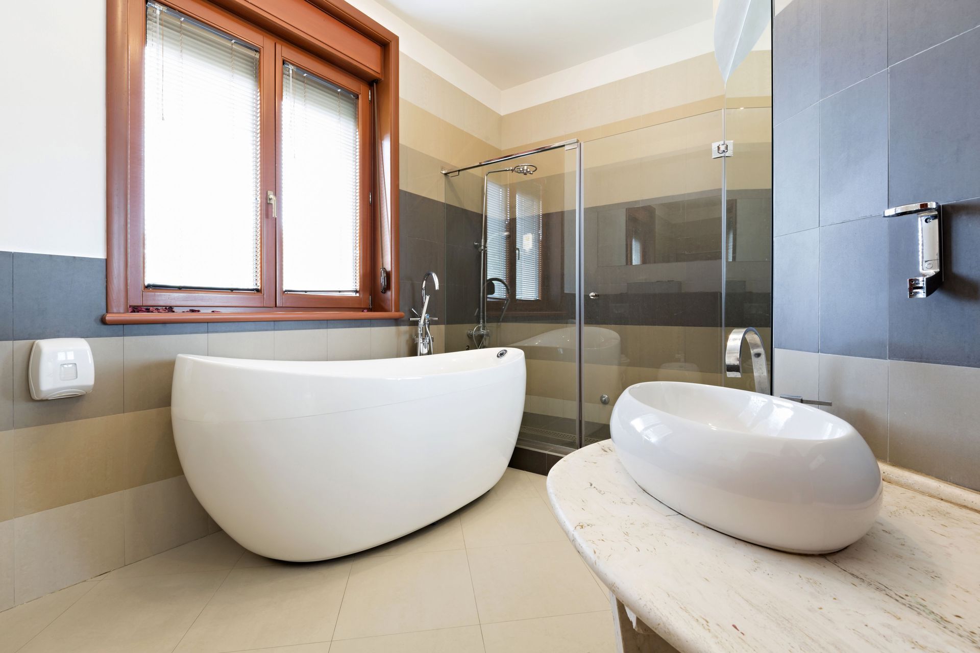 Modern bathroom with a white tub, vessel sink, and a glass shower.