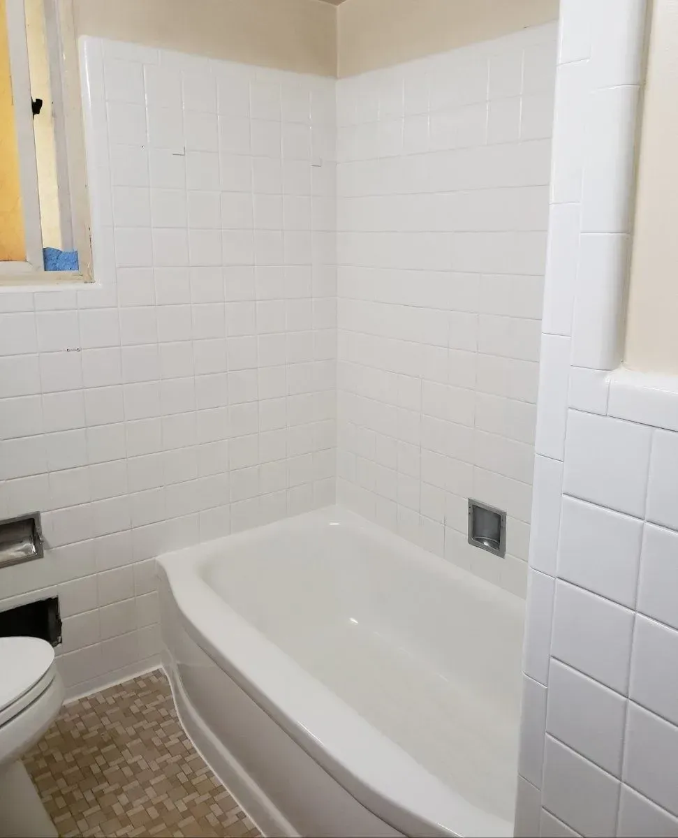 Modern bathroom with white walls, gray accent wall, and a soaking tub.