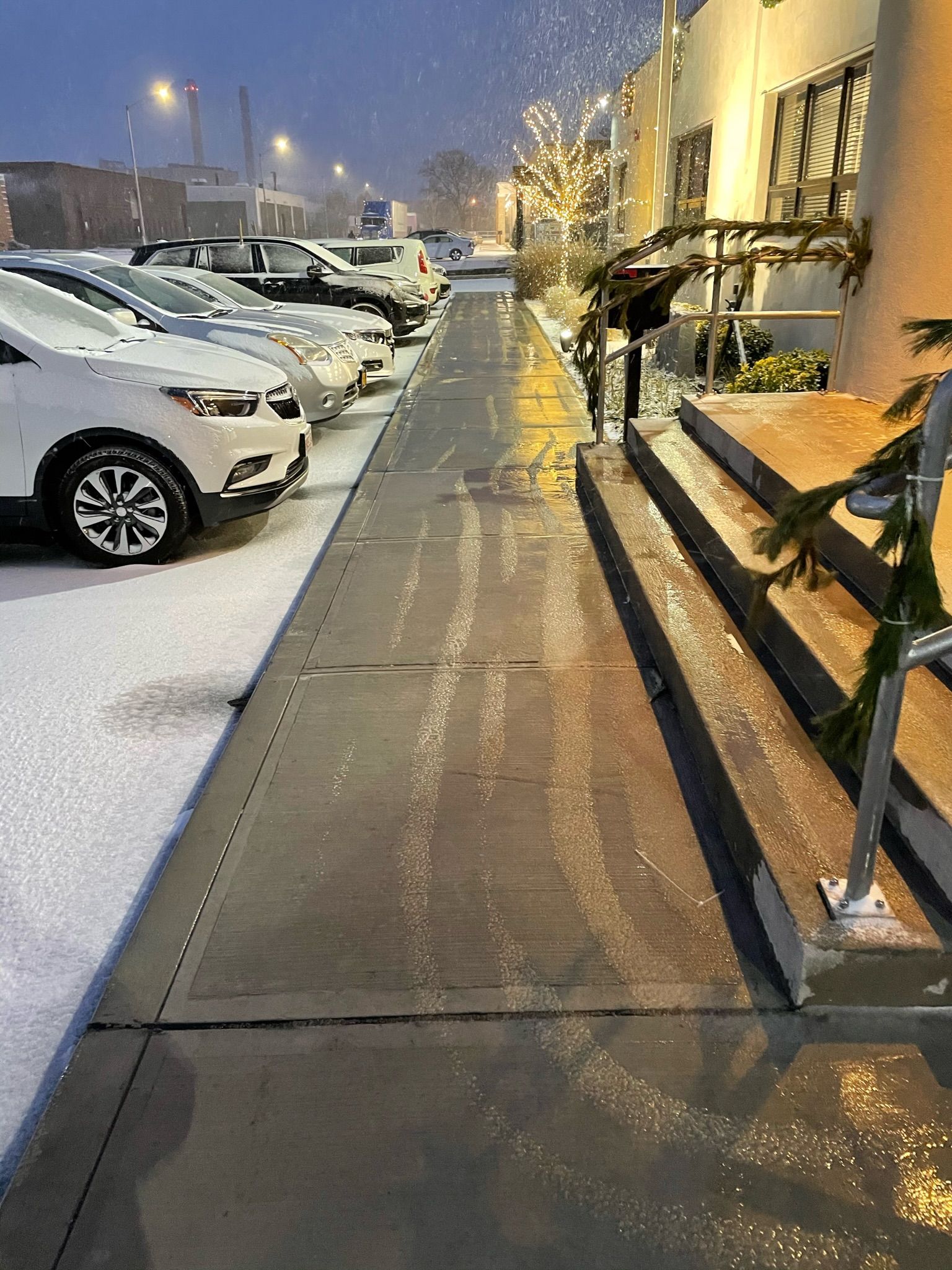 a row of cars are parked on a sidewalk in front of a building