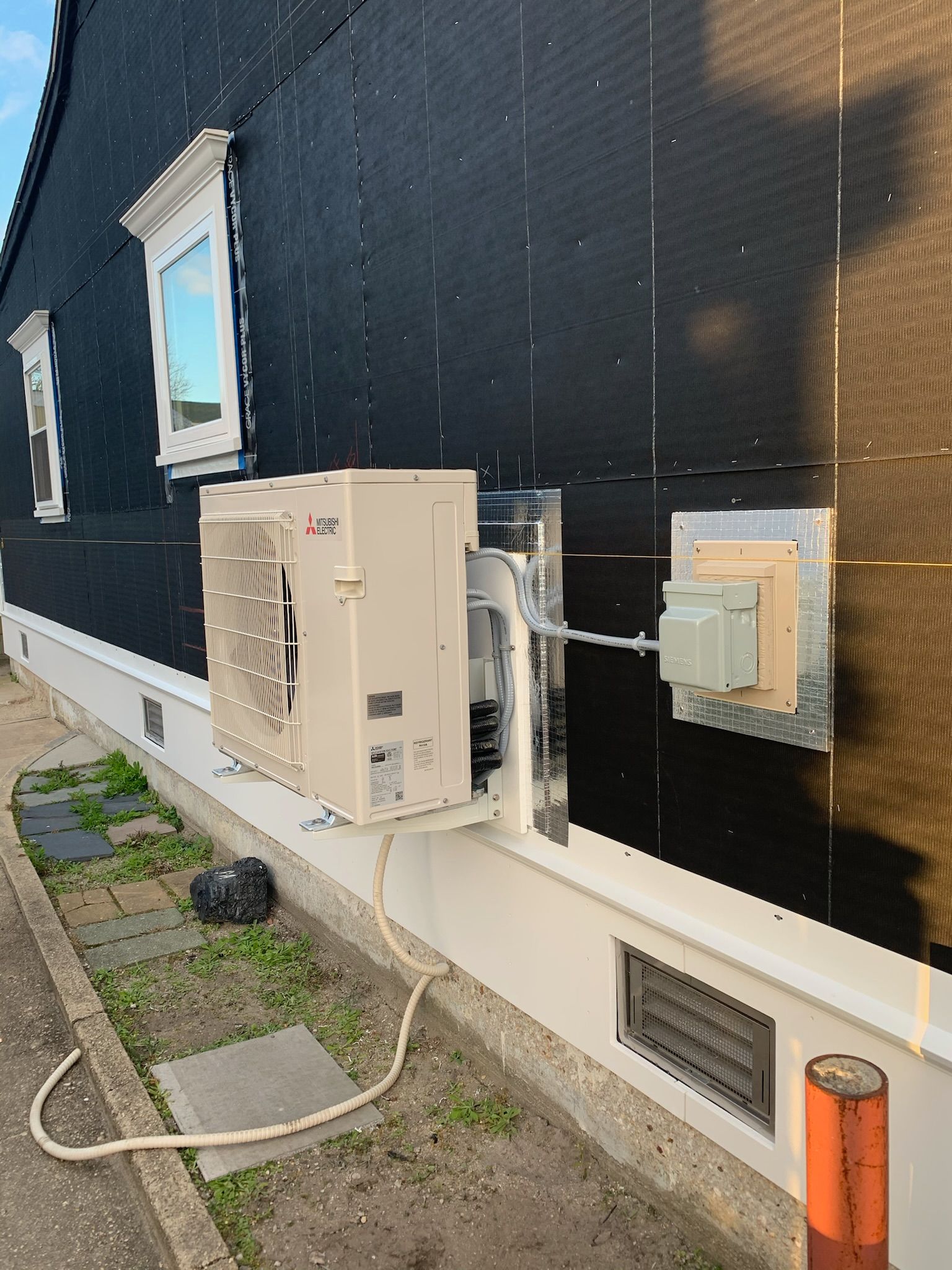 a white air conditioner is attached to the side of a building