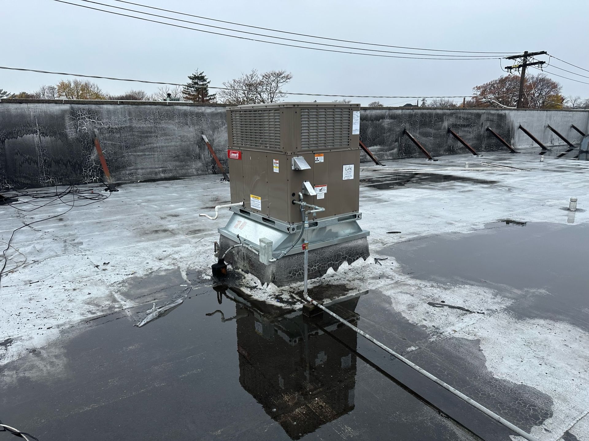 an air conditioner is sitting on top of a roof in a puddle of water