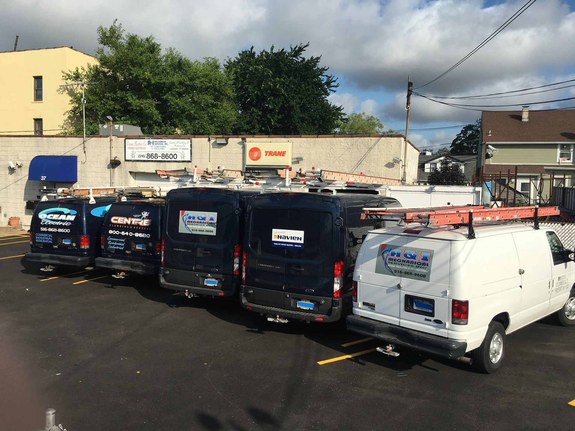 a row of vans are parked in a parking lot in front of a building
