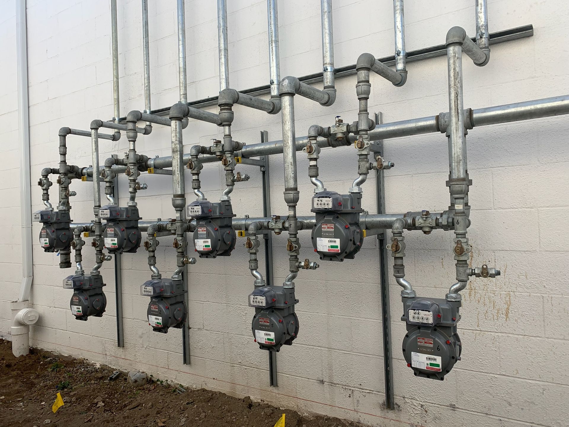 a row of gas meters mounted to a wall