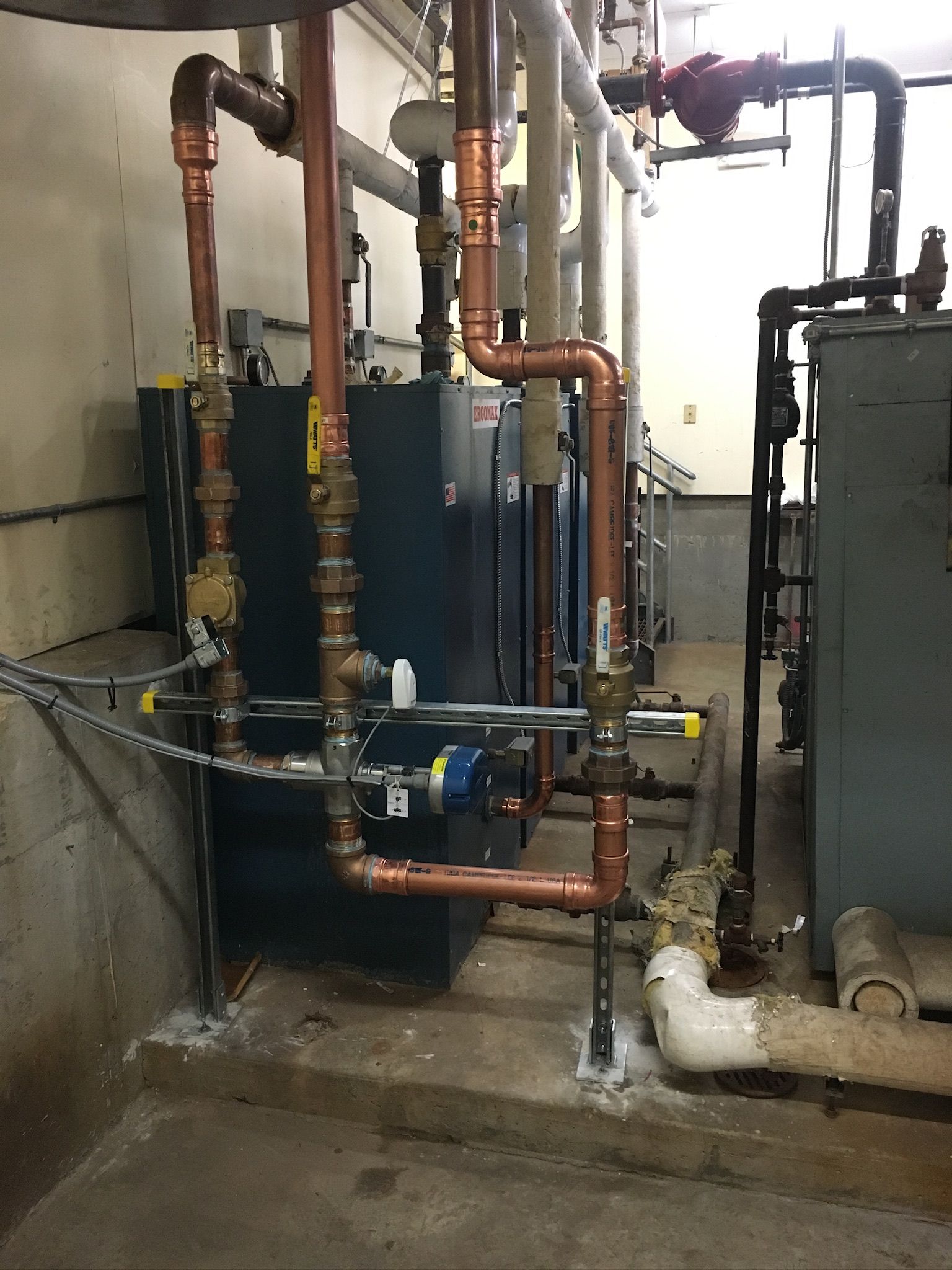 a room with a lot of pipes and a boiler