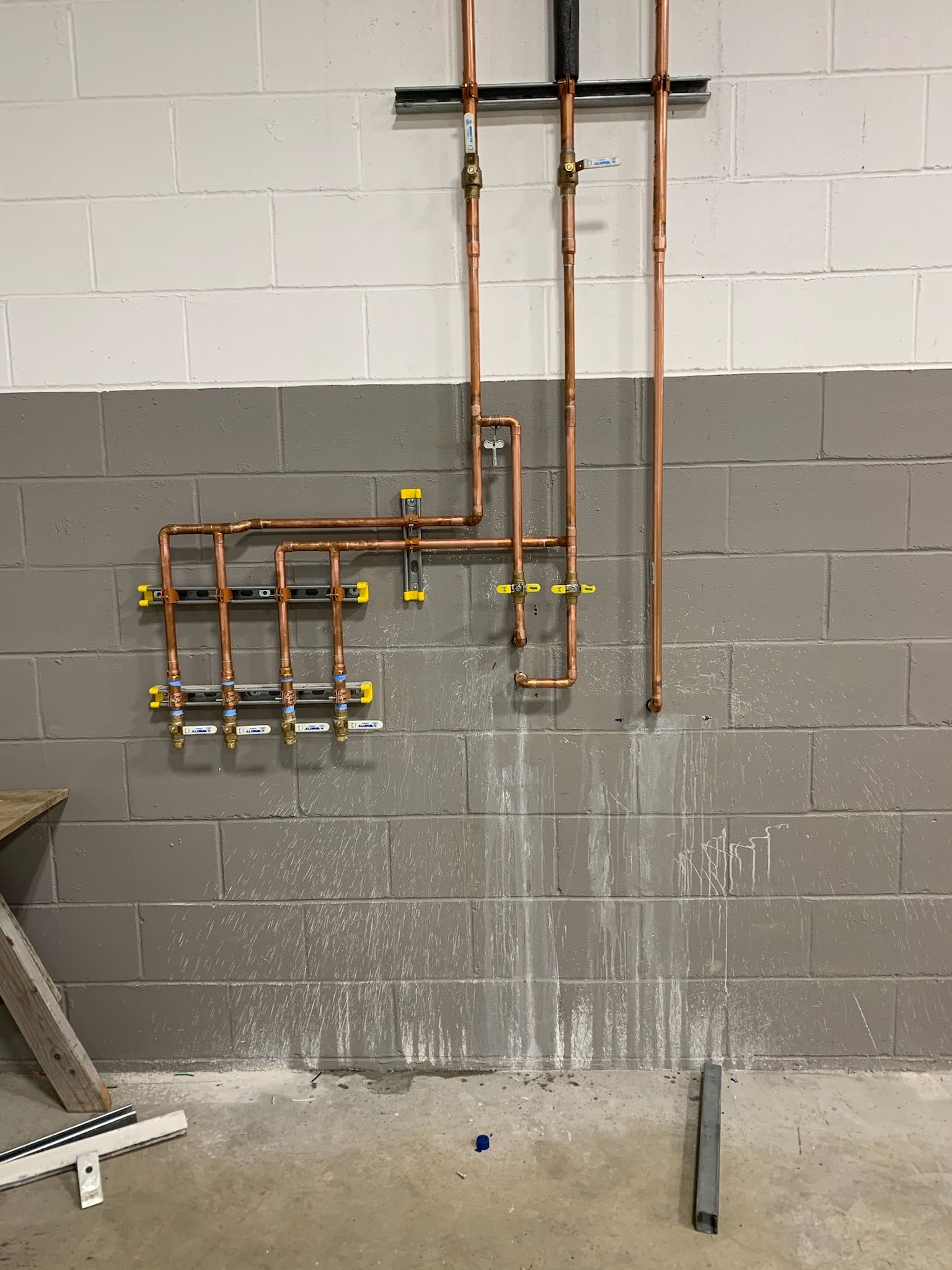 a brick wall with copper pipes hanging from it