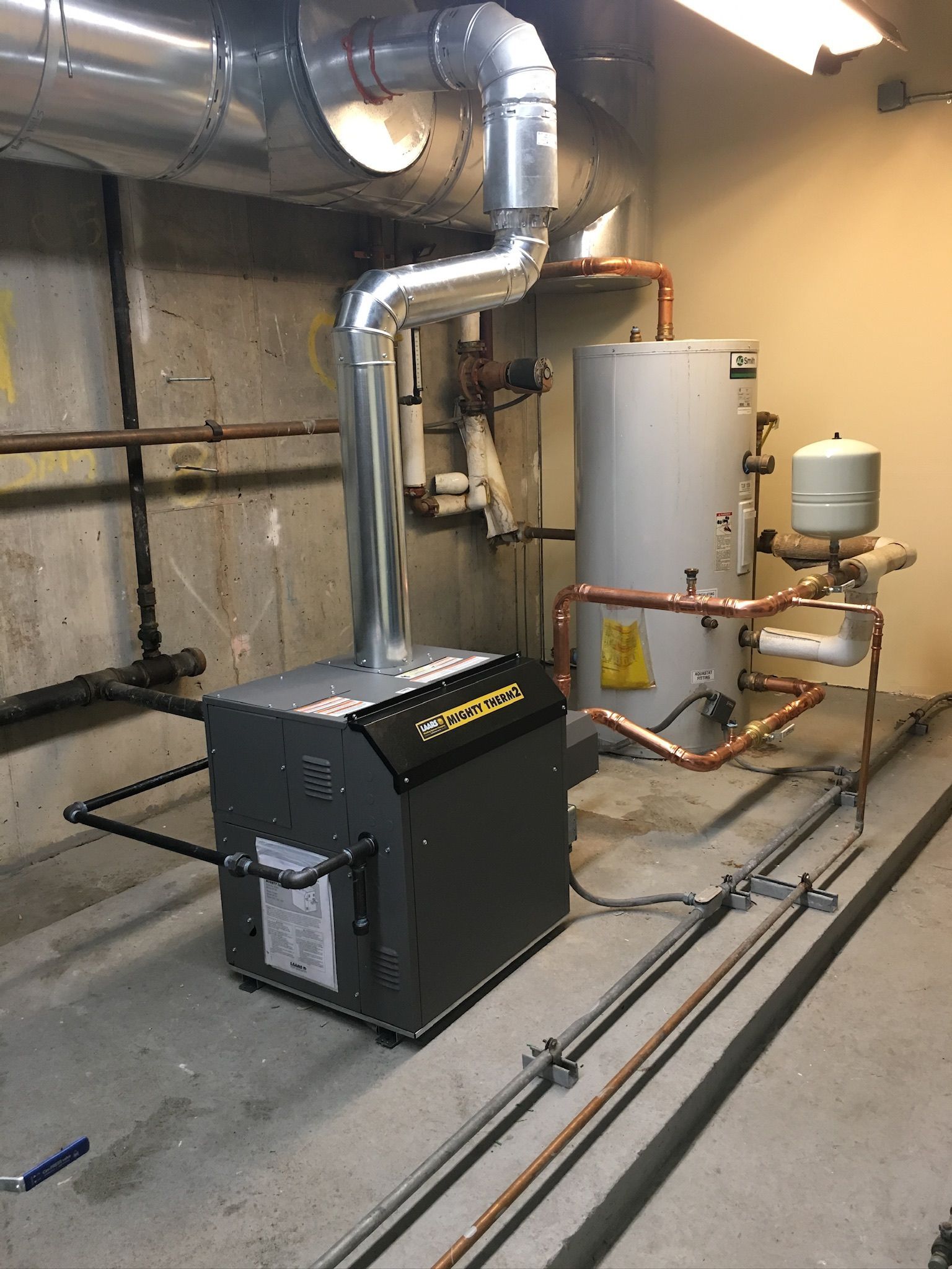 a boiler is sitting in a room next to a water heater