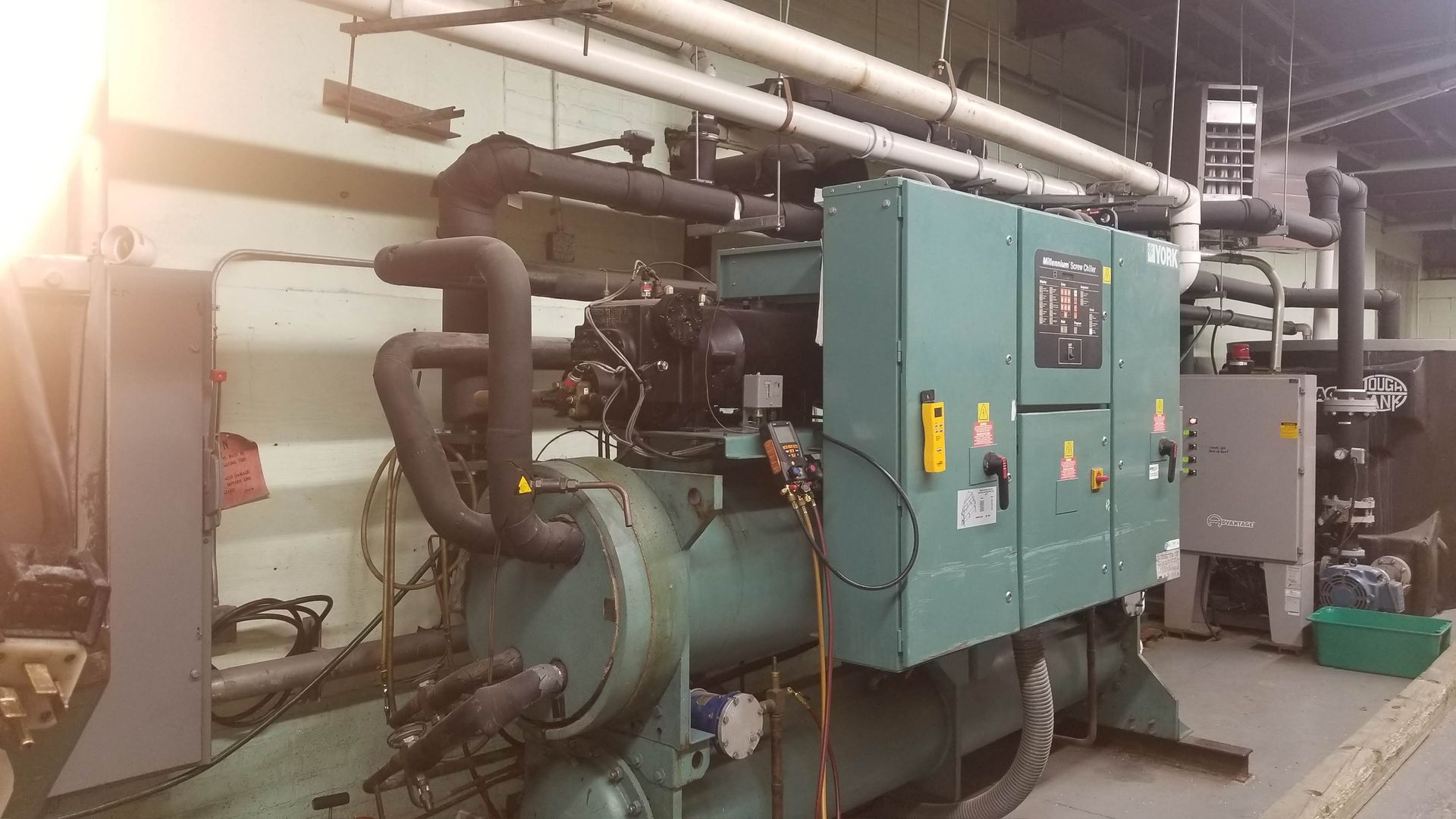 a large machine is sitting in a room with a lot of pipes