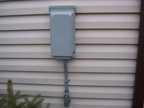 a gray box is attached to the side of a house