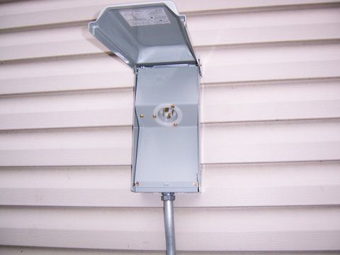 a box with the lid open is attached to a pole on the side of a house