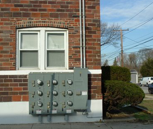 a brick building with a window and an electrical box on the side