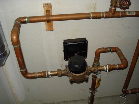 a copper pipe with a water meter attached to it