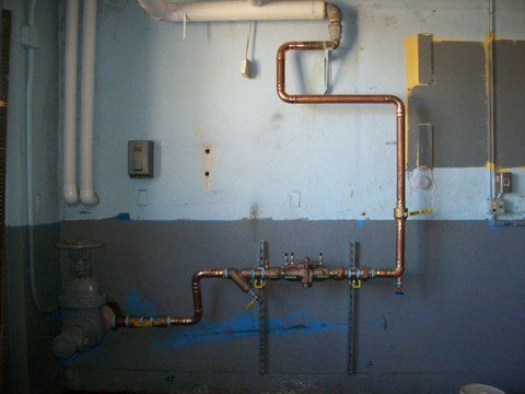 a copper pipe is hanging from a wall in a room