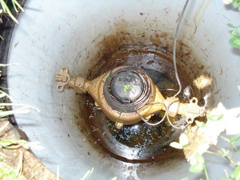 a close up of a water meter in a hole