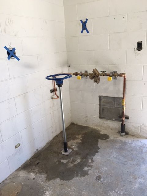 a room with white bricks and a blue x on the wall