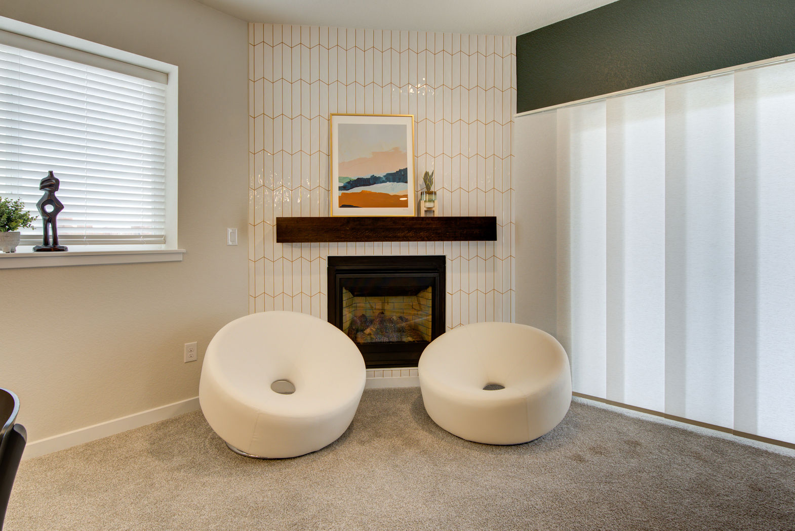 A living room with two chairs and a fireplace.