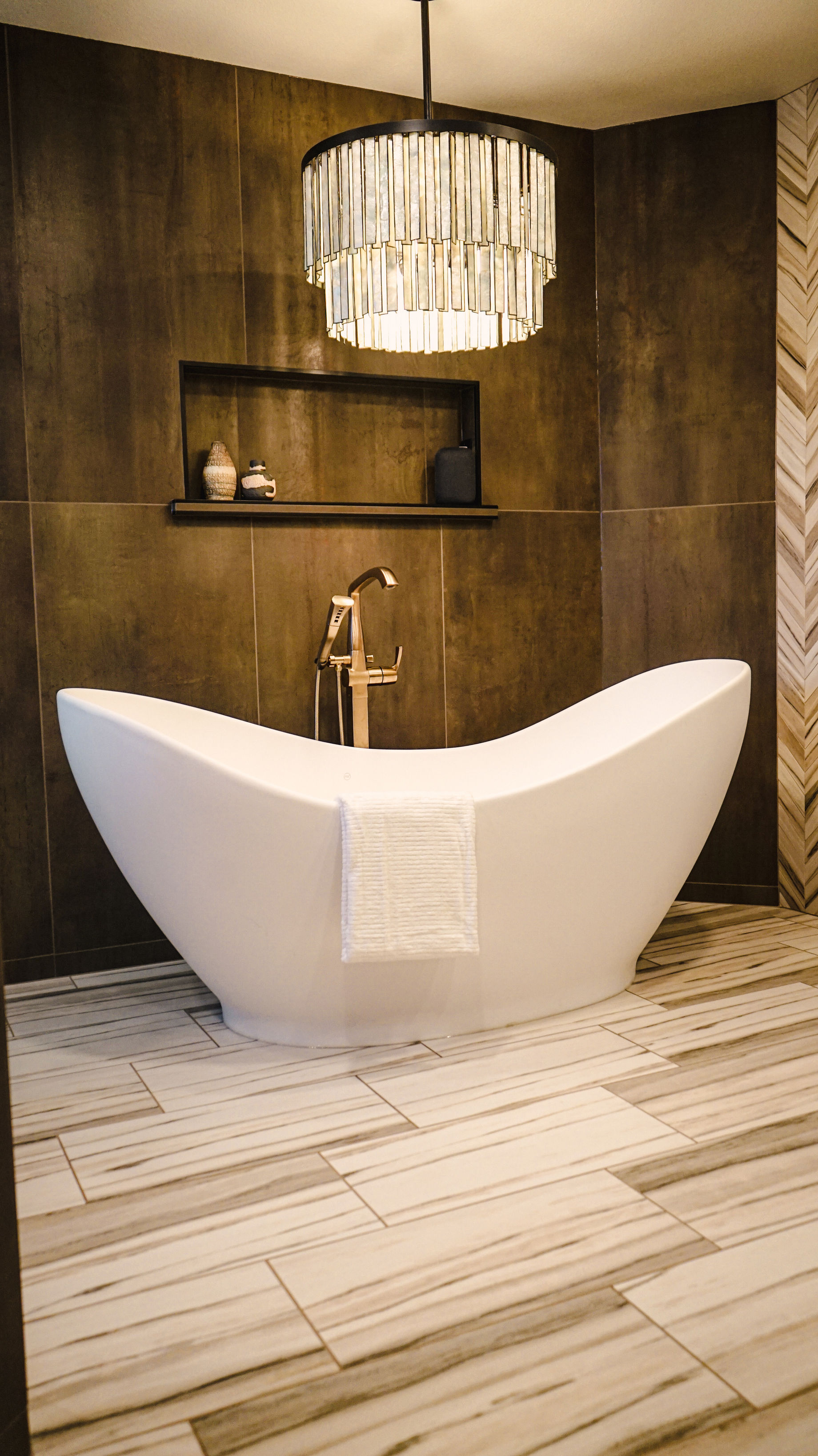A bathroom with a bathtub and a chandelier hanging from the ceiling.