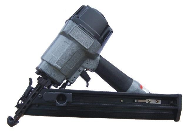 Gray pneumatic nail gun on a black rail, angled upward on a white background