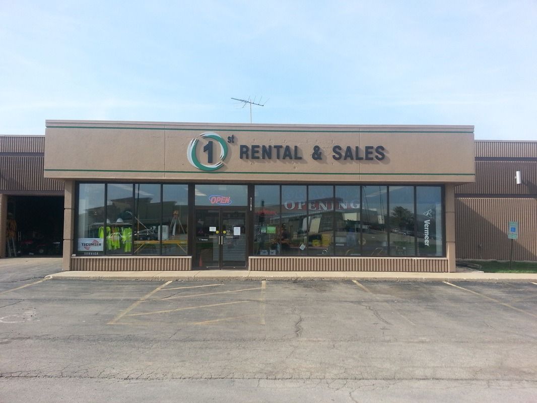 Storefront with “Rental & Sales” sign and large front windows in a strip mall parking lot