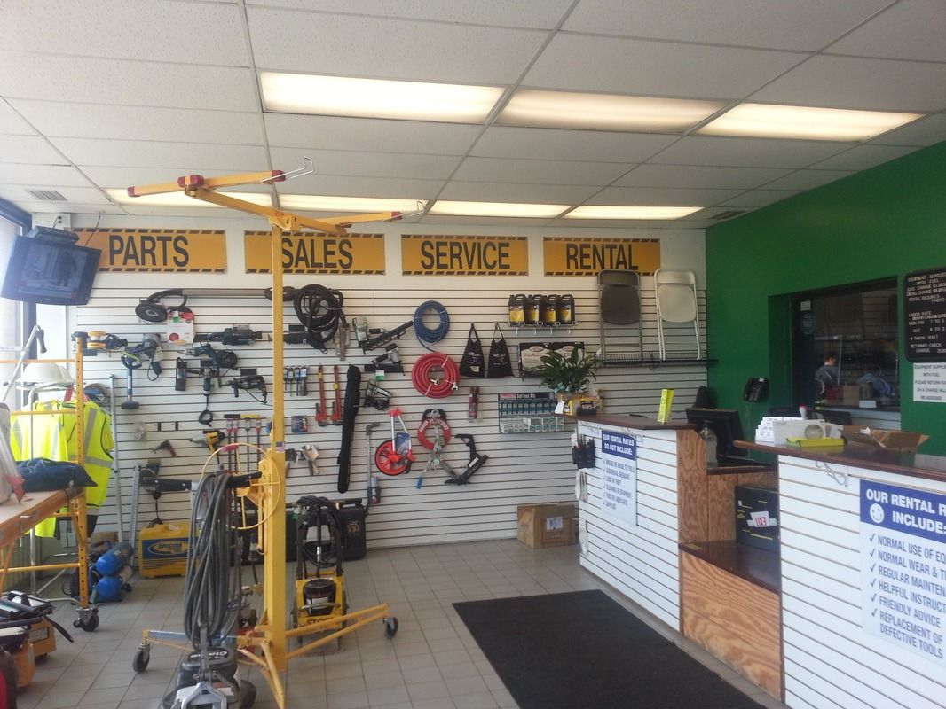 Motorcycle parts and service shop interior with shelves, tools, and yellow repair equipment