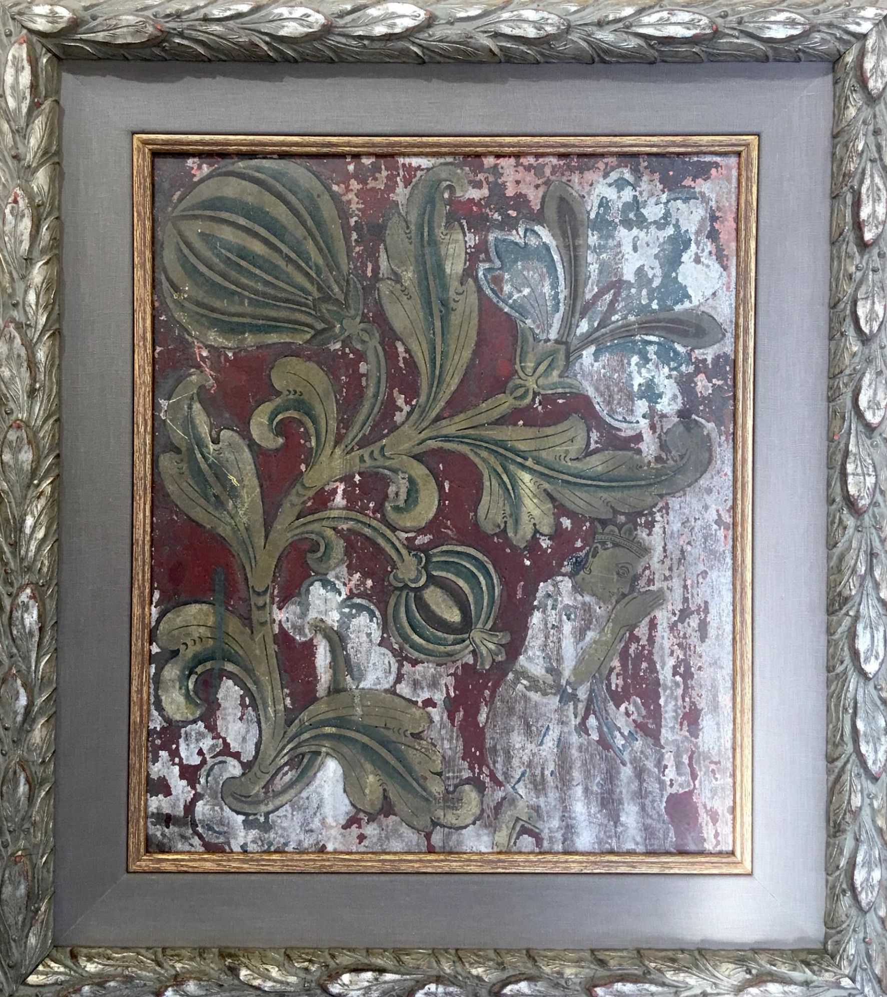 Framed artwork with distressed floral pattern in green and gold on a red background. The frame is ornate silver.