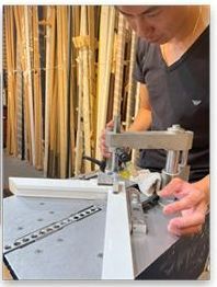 A man is using a machine to make a picture frame.