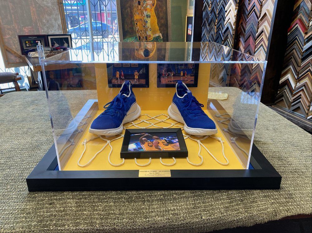 A pair of blue shoes in a display case on a table.