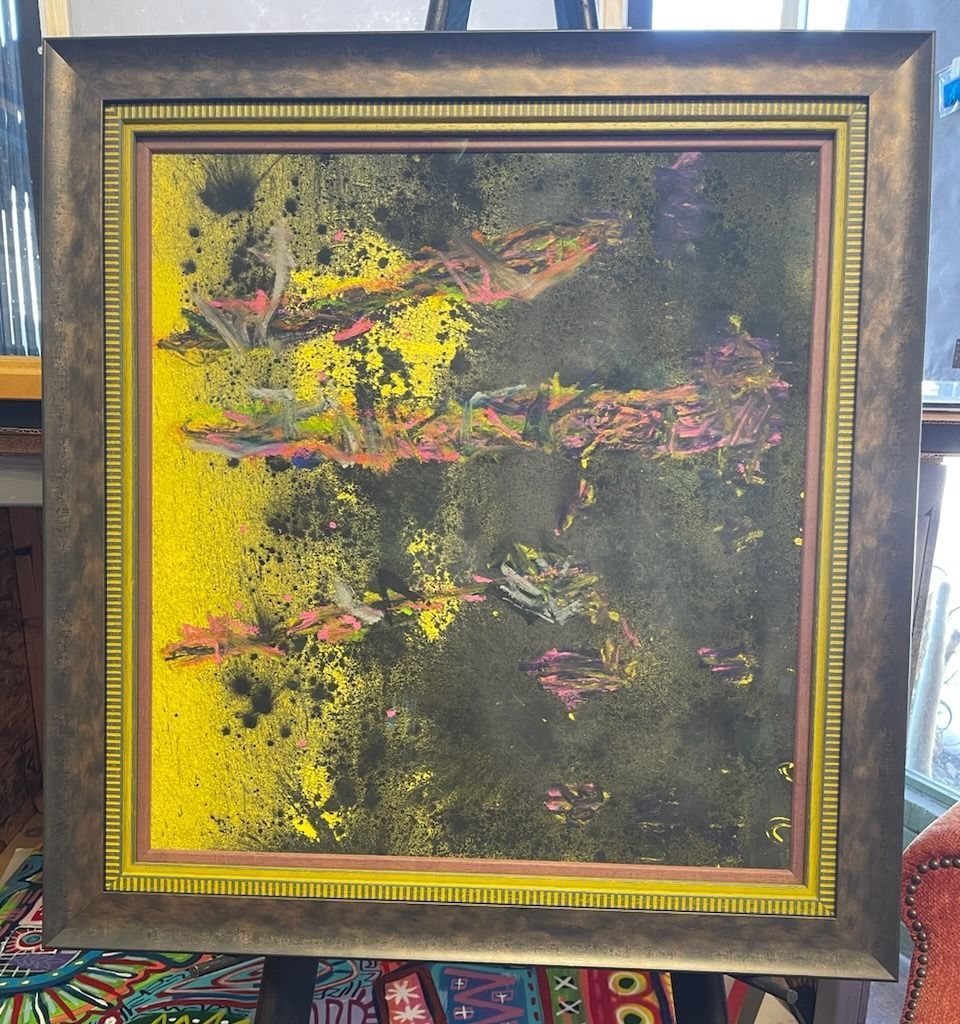 Abstract painting with yellow and black splatters, and pink and white shapes, framed in gold.