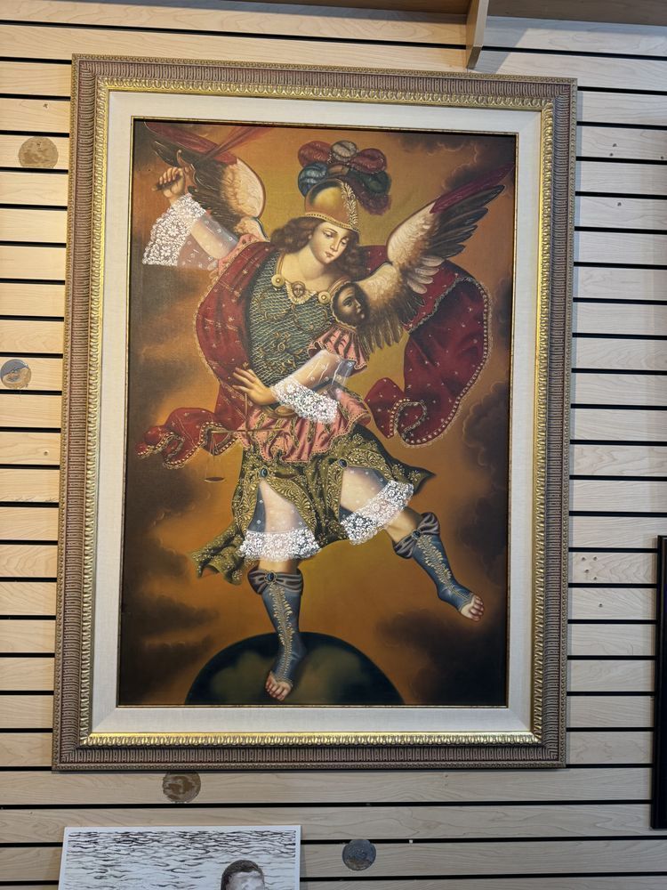 Painting of an angel in ornate armor with wings, set against a dark, cloudy background, inside a decorative gold frame.