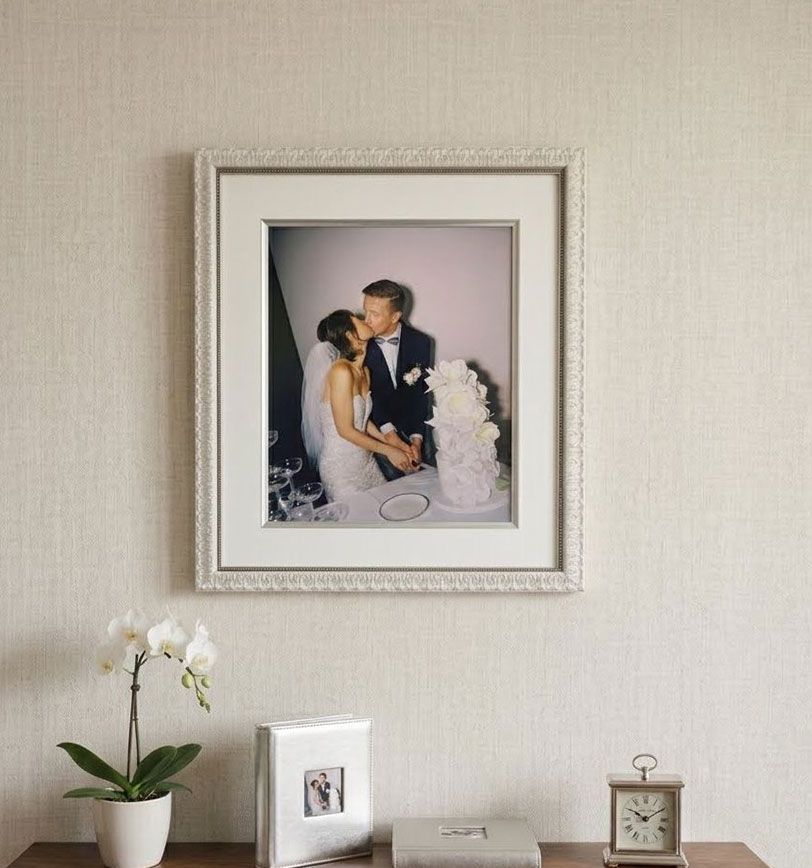 A framed wedding photo hanging on the wall.