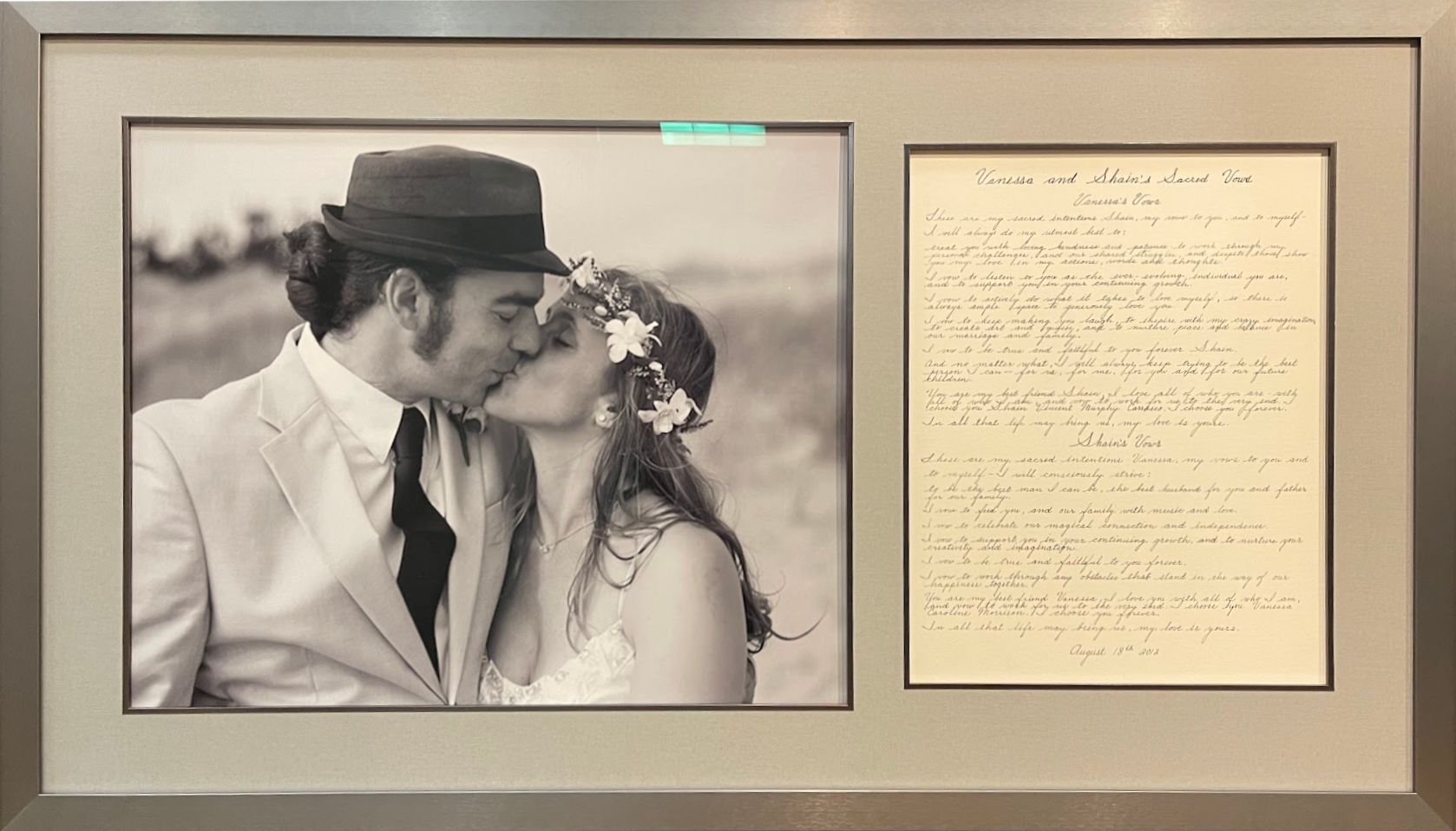 Framed wedding photo and handwritten note displayed side by side on a wall.