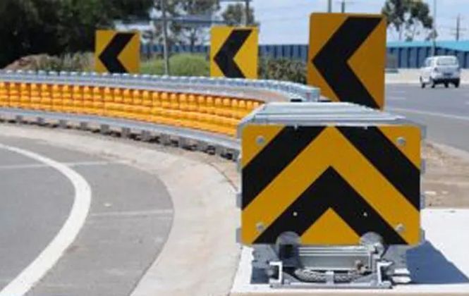 A yellow and black arrow sign on the side of a road