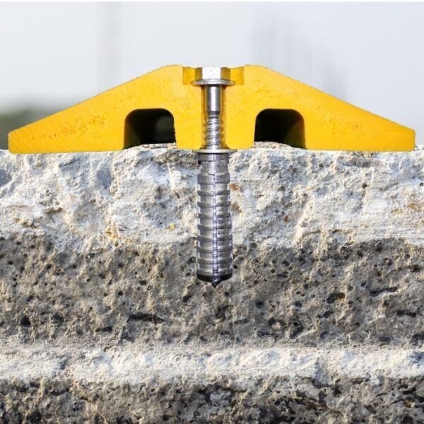 A screw is being screwed into a concrete surface