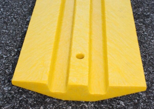 A yellow speed bump on the ground