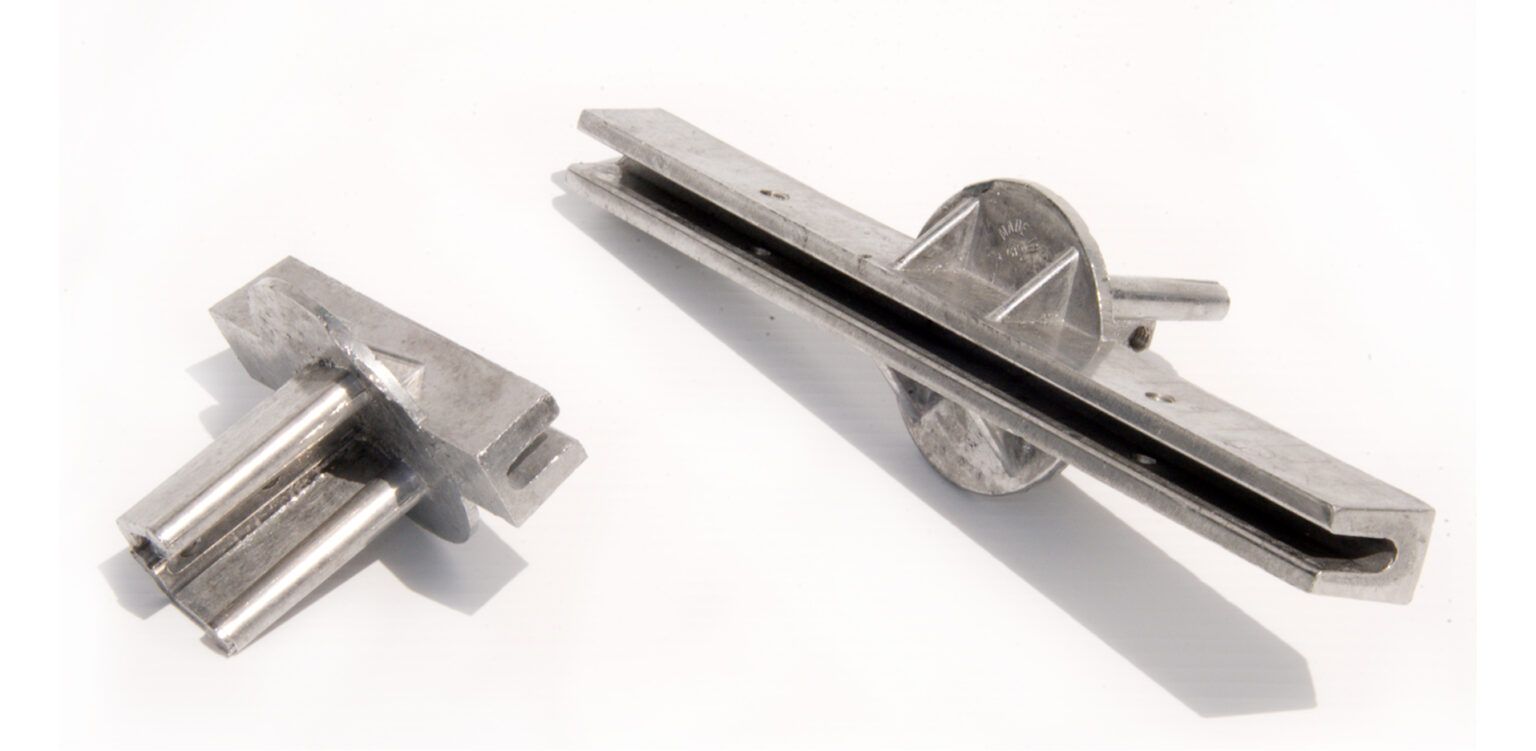 Two pieces of metal are sitting next to each other on a white surface.