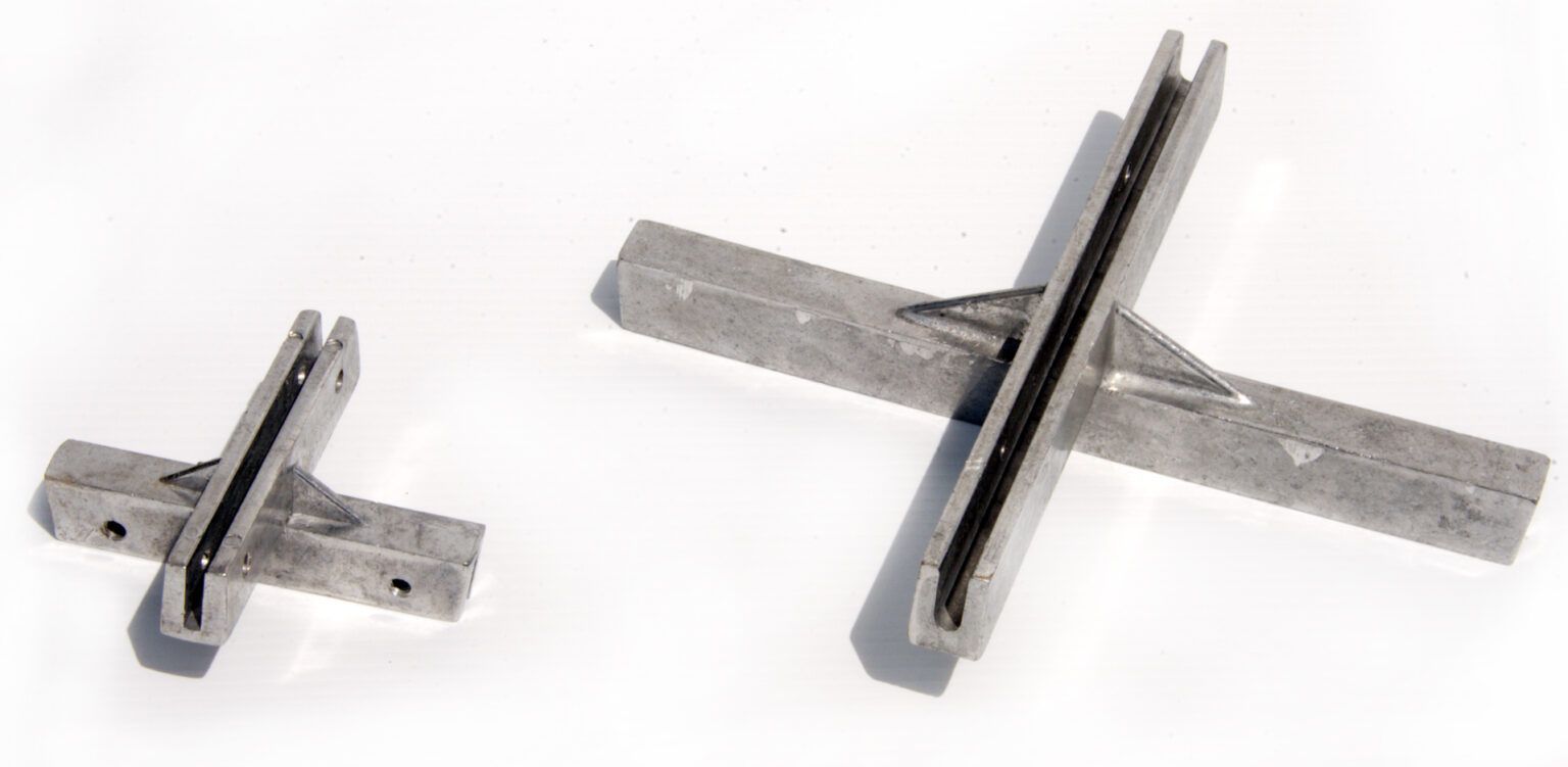 Two metal crosses are sitting next to each other on a white surface.