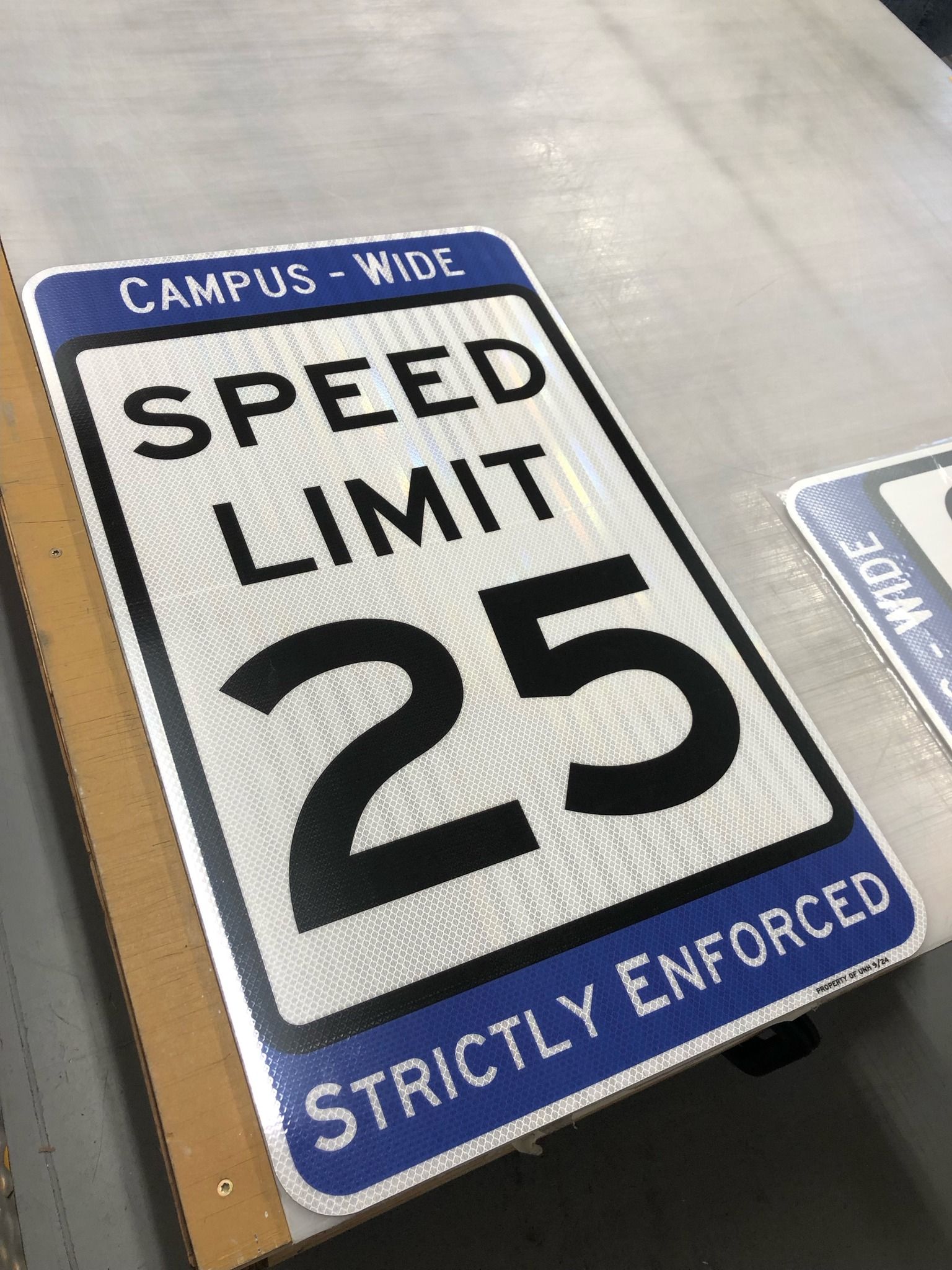 A speed limit sign is sitting on top of a cardboard box.