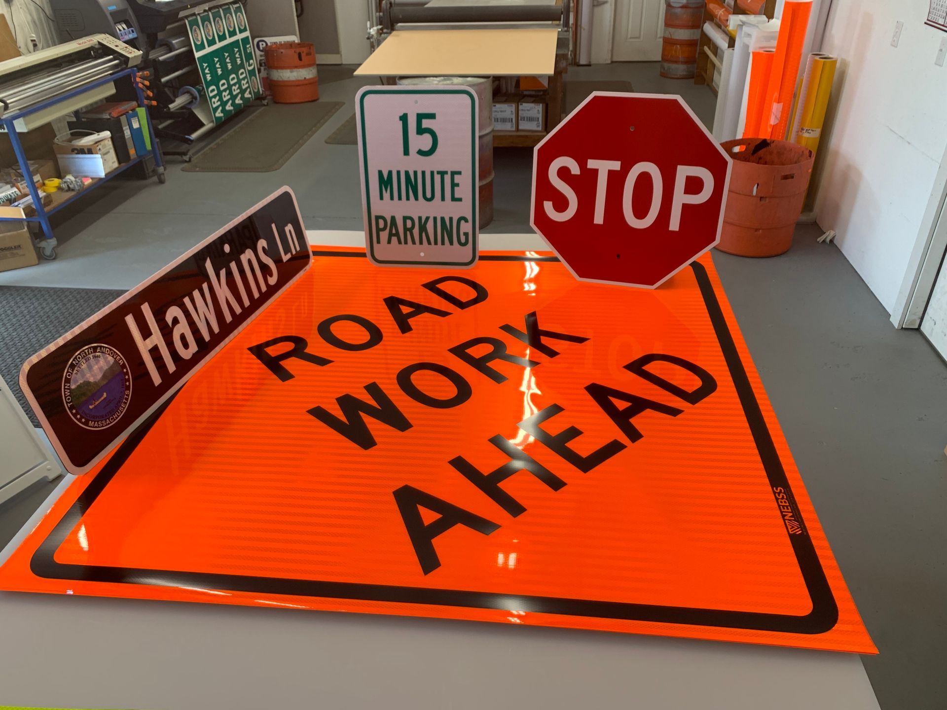 A stop sign is sitting on top of a sign that says road work ahead