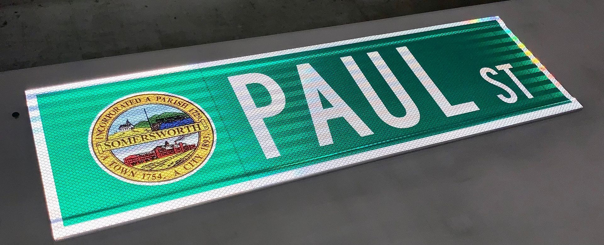 A green street sign that says paul st. on it