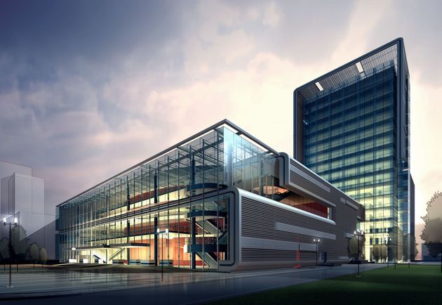 Modern glass office complex at dusk with a tower and illuminated lobby