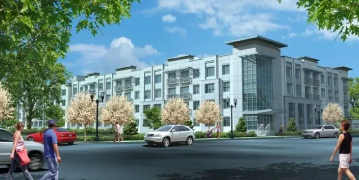 Modern apartment complex with landscaped trees, cars, and pedestrians on a sunny street