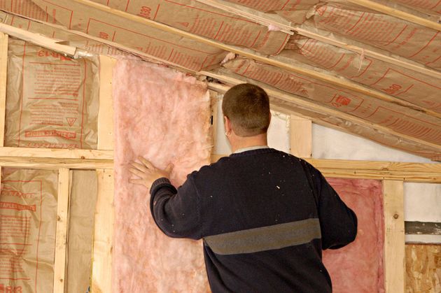 A man installing insulation